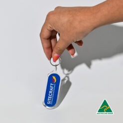 Hand holding blue branded keyring with corporate logo